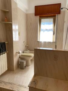 baño con aseo y lavabo y ventana en il sole nei templi, en Castelvetrano Selinunte