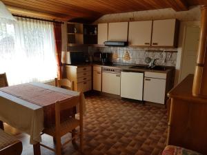 a kitchen with a table and a table and a window at Haus Waldblick in Hohegeiß