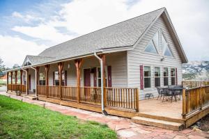 een wit huis met een terras en een tafel bij Old Man Mountain, Spacious lodge with loft Great for families, Dogs allowed in Estes Park