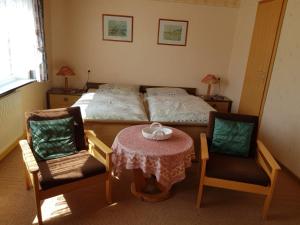 a bedroom with a bed and a table and chairs at Haus Waldblick in Hohegeiß