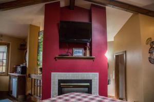 a living room with a red wall with a fireplace at Sundance Suite, 1 Bedroom with fireplace Dogs OK in Estes Park