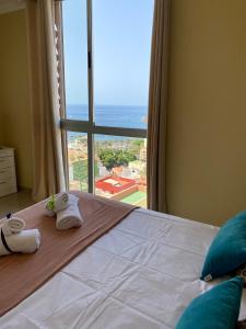 - une chambre avec une grande fenêtre et des serviettes sur un lit dans l'établissement Gurugú 2, à San Sebastián de la Gomera
