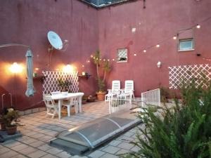 a patio with a tub and chairs and a red wall at A Casa di Monica in Pozzuoli