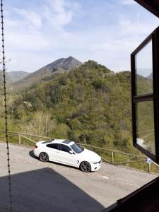 a white car parked on a road near a window at Aparatamento Rural El Oso 3 in Pola de Somiedo