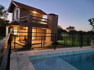 梅洛Cabañas San Pío的一栋房子前面有游泳池