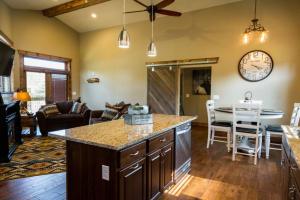 a kitchen and living room with a table and a clock at Spacious 2nd story loft with awesome views in Estes Park