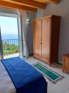 ein Schlafzimmer mit einem Bett und einem großen Fenster in der Unterkunft B&B Casa Martino SEA VIEW in Vietri