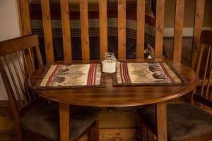 uma mesa de madeira com um guardanapo e uma garrafa em Mummy Mtn Suite 1 Bedroom suite with fireplace and jacuzzi tub em Estes Park