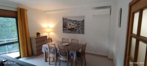 a dining room table and chairs in a room at Appartement Quinta de Palames Sesimbra in Sesimbra