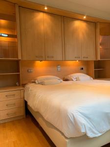 una camera con un grande letto bianco e armadi in legno di lovely two bedroom apartment with free parking ad Anversa