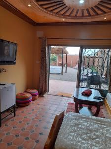 uma sala de estar com um sofá e uma televisão em Petit paradis em Sidi Bibi
