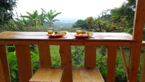 una mesa de madera con dos platos de comida. en Aventura Treehouse Glamping en Palmira
