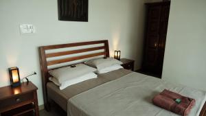 a bedroom with a large bed with a wooden headboard at Neela Waters - Beach Home in Alleppey