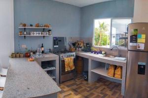 uma cozinha com um fogão, um lavatório e um frigorífico em Departamento cómodo vacacional em Manta