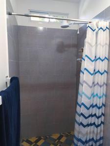 eine Dusche mit einem blauen und weißen Duschvorhang im Bad in der Unterkunft Departamento cómodo vacacional in Manta