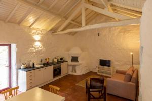 een keuken en een woonkamer met een bank en een tafel bij Casas do Capitão - Paiva Valley - Pool and Nature in Castelo de Paiva
