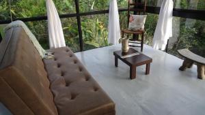 sala de estar con sofá y silla en Cristal House Glamping at Villa Migelita Ecolodge, en Palmira