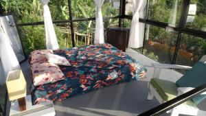 1 cama con edredón de flores y almohadas en Cristal House Glamping at Villa Migelita Ecolodge, en Palmira