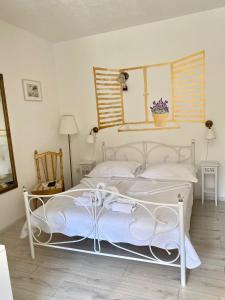 een wit bed in een witte slaapkamer met een spiegel bij Apartments Franka in Samobor