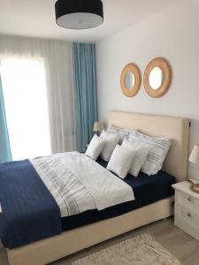 ein Schlafzimmer mit einem Bett mit blauen und weißen Kissen in der Unterkunft Niebieski in Rewal