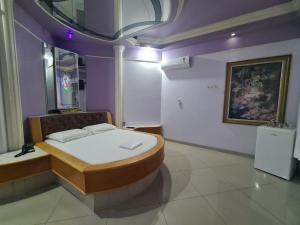 a bedroom with a bed in a room with purple walls at Euro Motel (Only Adults) in Viracopos