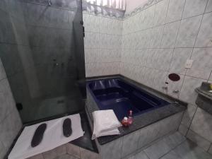 a bathroom with a tub with a sink and a shower at Euro Motel (Only Adults) in Viracopos