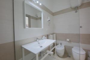 a bathroom with a sink and a toilet and a mirror at Hotel Corallo in Torre Santa Sabina +57 photos