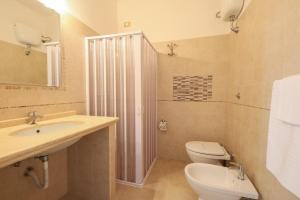 a bathroom with a toilet and a sink and a shower at Hotel Corallo in Torre Santa Sabina