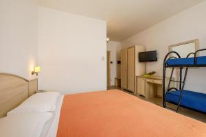 a bedroom with two bunk beds and a television at Hotel Corallo in Torre Santa Sabina +37 photos