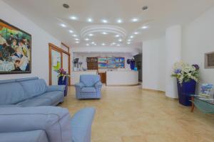 a living room with blue couches and a table at Hotel Corallo in Torre Santa Sabina