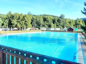 a large blue swimming pool with a wooden fence at LOFT WAPITI in Hutisko