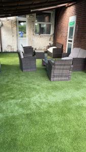 a patio with chairs and a table on a lawn at Hotel in Harrow