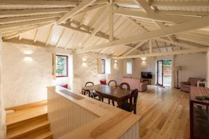 a living room with a wooden table and chairs at Casas do Capitão - Paiva Valley - Pool and Nature in Castelo de Paiva