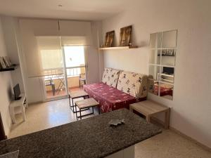 salon z kanapą i stołem w obiekcie Apartamento céntrico en Tarifa. w mieście Tarifa