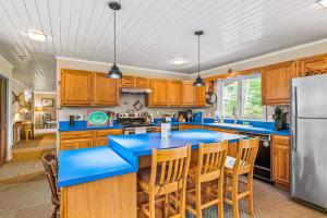 kuchnia z niebieskimi blatami i drewnianymi szafkami w obiekcie Five Chimneys Lake House w mieście Schroon Lake