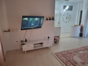 a living room with a flat screen tv on a wall at Appartement carthage in Douar ech Chott