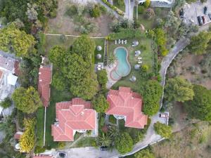 Cette chambre offre une vue sur une maison dotée d'une piscine et d'arbres. dans l'établissement Villa Xanthippi, à Agia Paraskevi