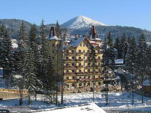 a large building in the snow with a mountain at 100 metriv vid vytyagu in Bukovel