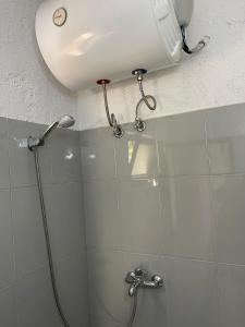a bathroom with a shower with a phone on the ceiling at Ona's House in Borsh