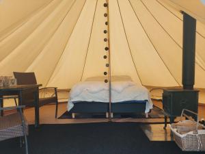 a bedroom with a bed in a tent at Villmarksgård camping in Hattfjelldal