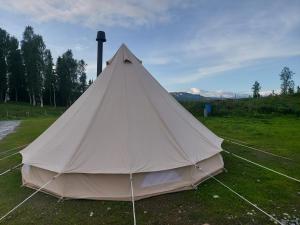 a large white tent sitting in a field at Villmarksgård camping in Hattfjelldal +5 photos
