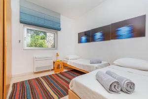 1 dormitorio con 2 camas y ventana en Villa Bobara, en Mlini