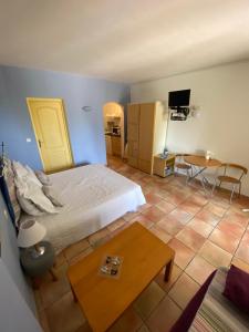 1 dormitorio con cama, mesa y TV en Les Arcades, en Fayence