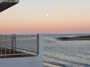 a view of the ocean from a pier at sunset at Apartamentos Alborada in La Paloma