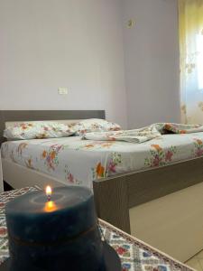 博許的住宿－Ona's House，一间设有两张床的房间和一张桌子上的蜡烛