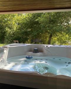 une baignoire jacuzzi devant une fenêtre dans l'établissement Quinta Gerês, à Terras de Bouro