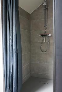 a shower with a blue shower curtain in a bathroom at B&Bie ons in Bad-Nieuweschans