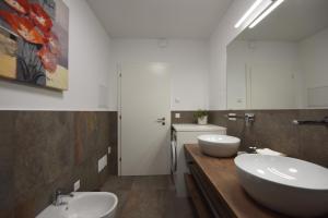 a bathroom with two sinks and two mirrors at CityChalet romantic Bozen in Bolzano