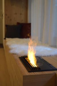 a fire on top of a table on a bed at CityChalet romantic Bozen in Bolzano