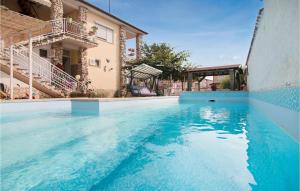 - une piscine en face d'une maison dans l'établissement Amazing Apartment In Valbandon With Outdoor Swimming Pool, à Valbandon
